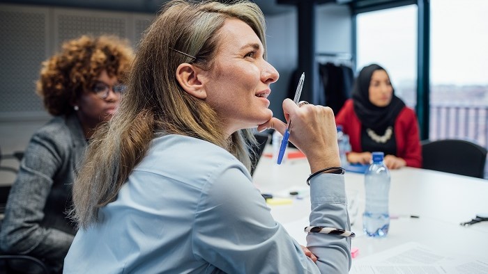 a woman holding a pen and looking away