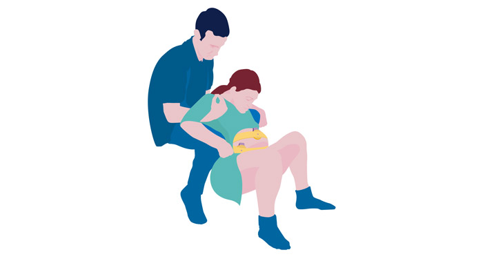 a man helping a woman to stretch her belly